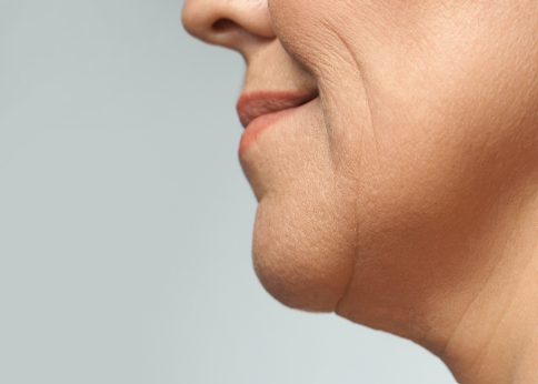 A woman with a small neck poses, showcasing her delicate features and elegant appearance. A woman with a small neck poses, showcasing her delicate features and elegant appearance.