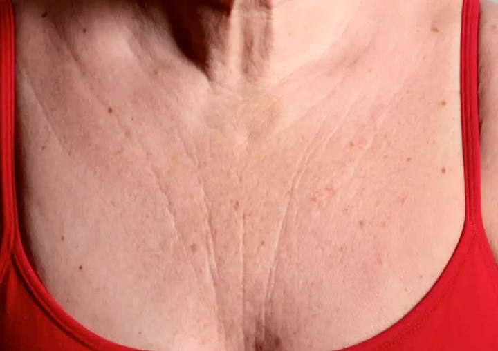 A woman wearing a red bra, showcasing her large chest in a confident pose.