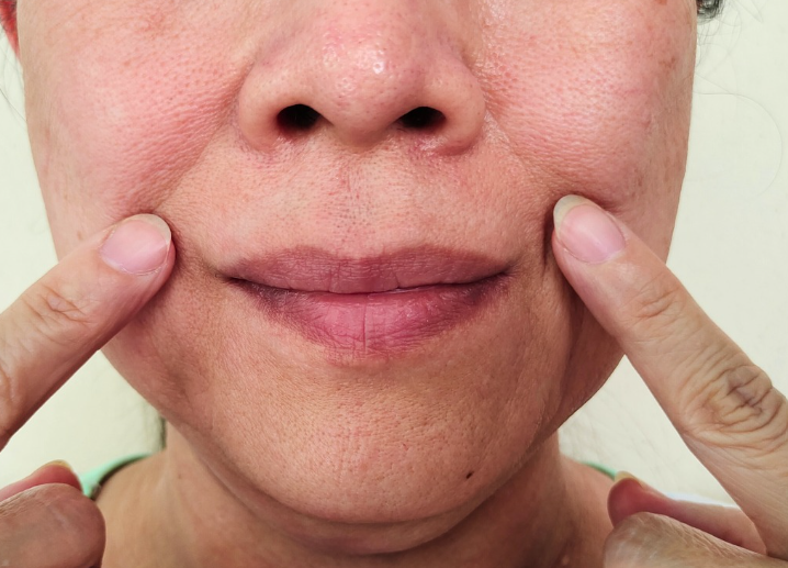 A woman with her hands on her face, expressing surprise or contemplation. A woman with her hands on her face, expressing surprise or contemplation.